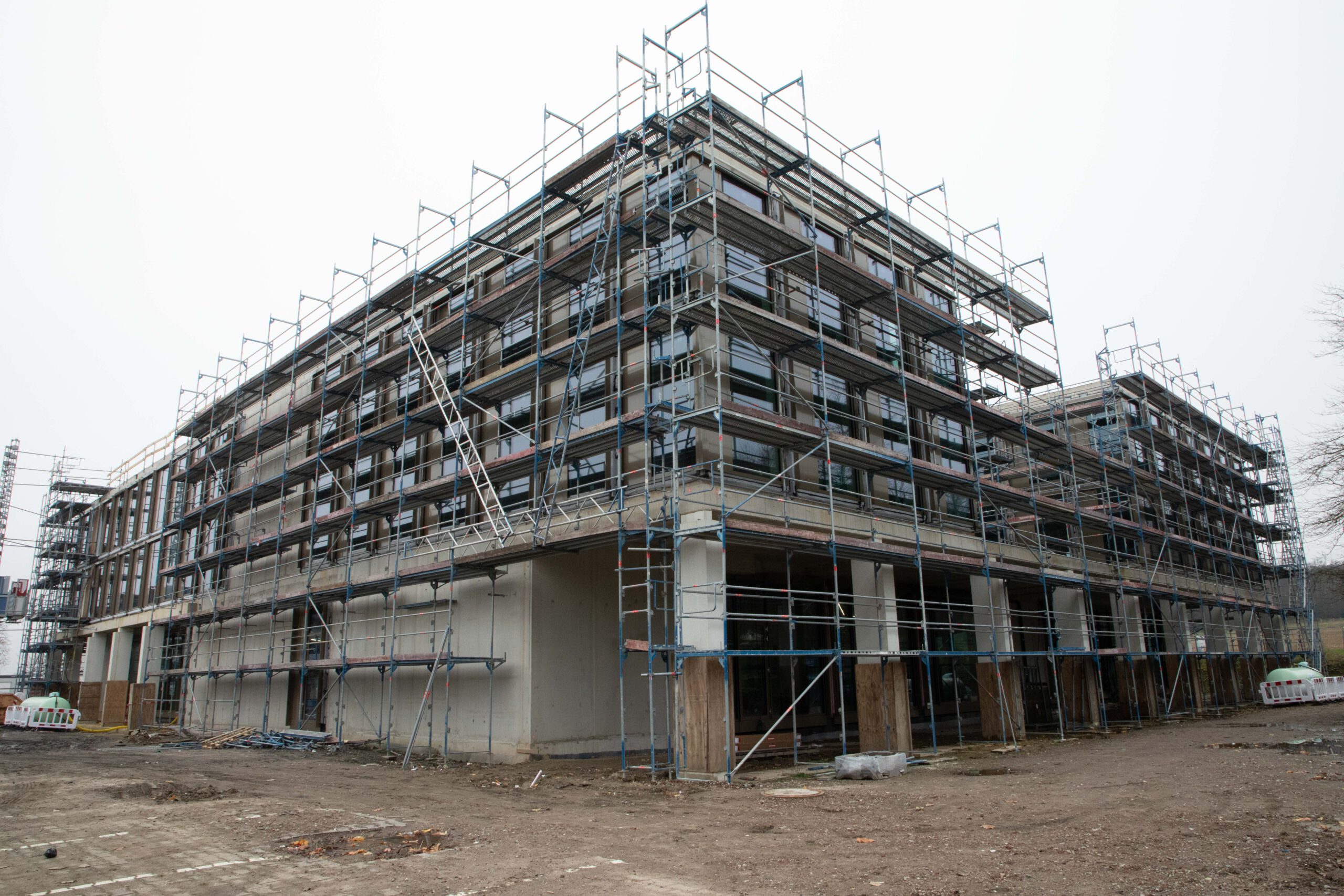Gebäude im Bau mit Gerüst, moderne Architektur, Baustelle in urbaner Umgebung.